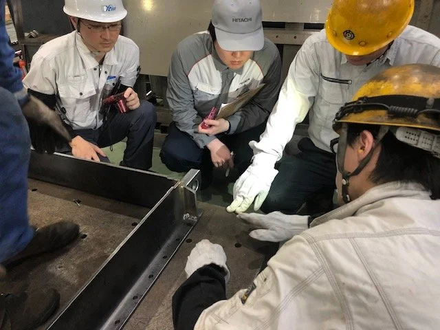 ノギスと図面を使って金属部品の寸法を確認している手元