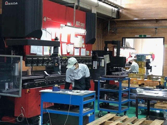 加工後の金属部品の寸法と表面状態を手元で確認している検査作業